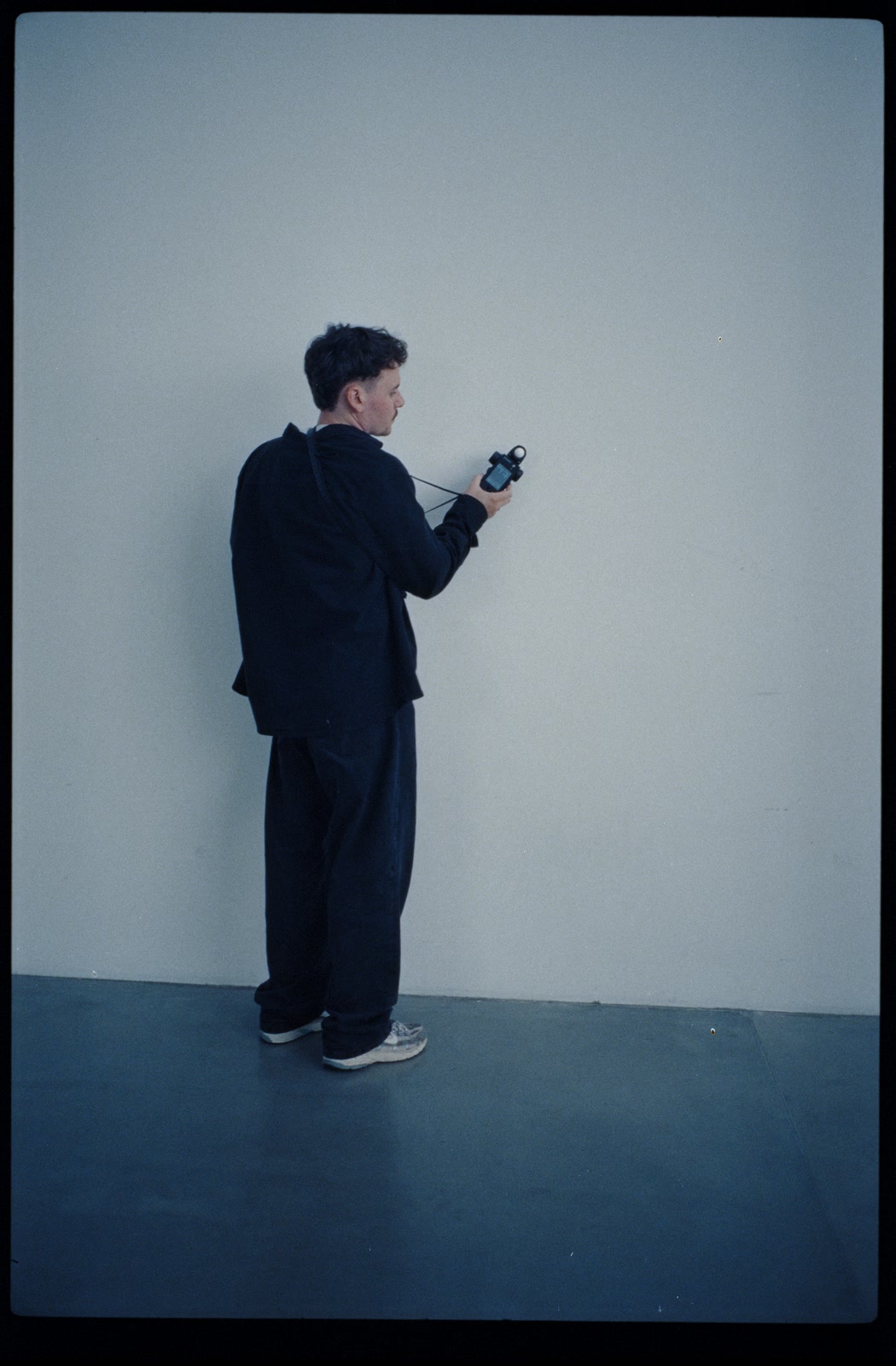 Tim Bieker, Director of Photography, taking a light meter reading on set in Berlin